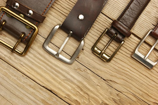 leather belt with a buckle on a wooden board